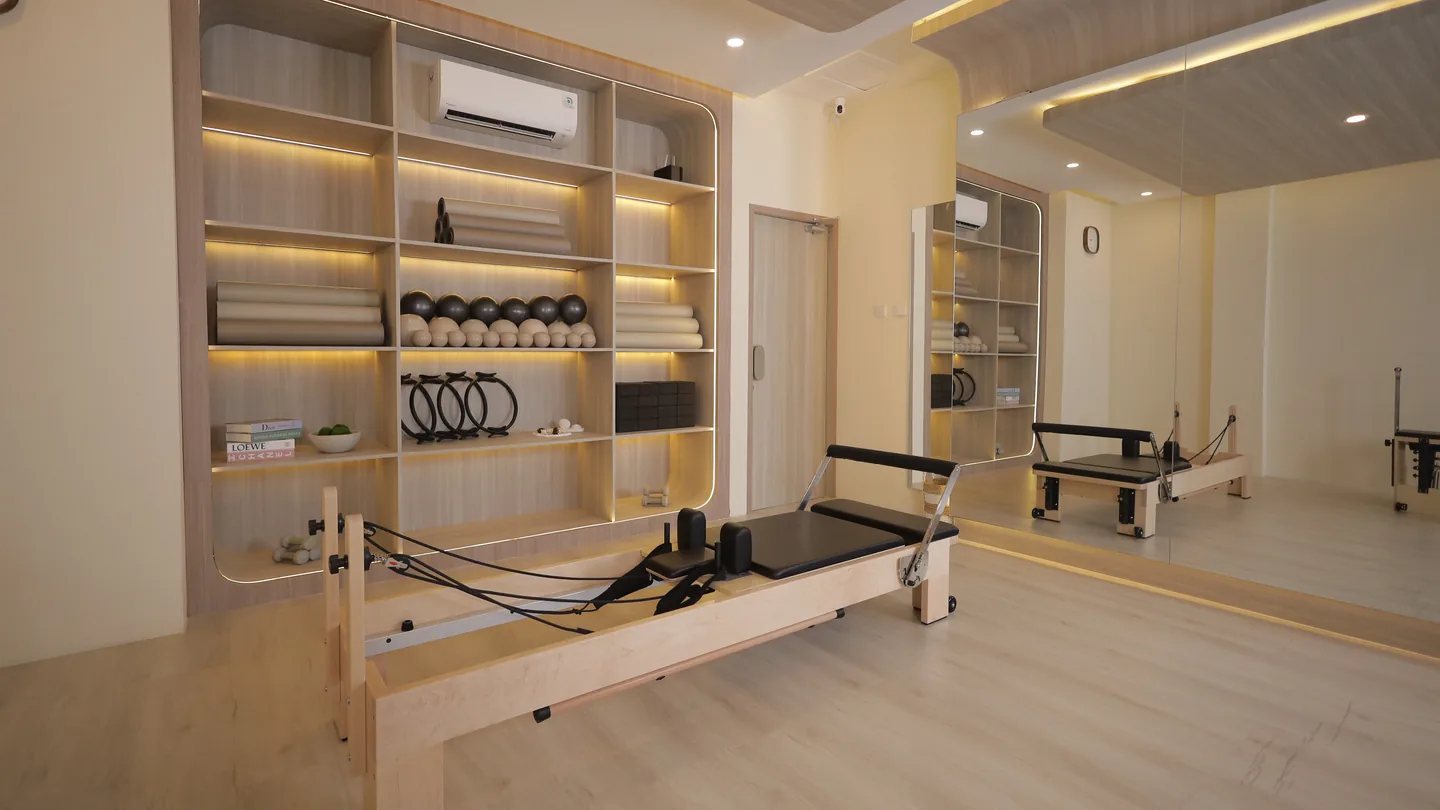 A reformer facing the lit prop wall of rings, rollers and balls